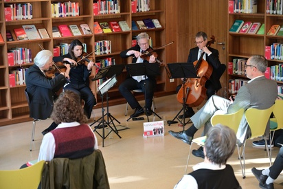 Ein Streicherquartett spielt in einer Bibliothek vor einem Publikum. © ESF / Christopher Glanzl