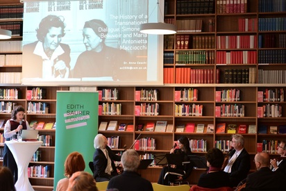 Eine Frau hält einen Vortrag in einer Bibliothek, ein Streichquartett und das Publikum hört ihr zu. © ESF / Christopher Glanzl
