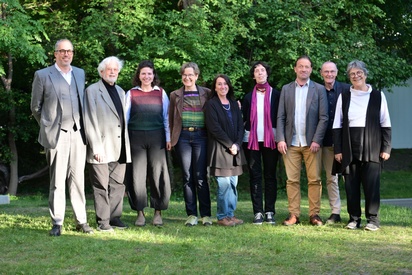 Eine Gruppe von neun Personen steht in einem Garten und blicken lachend in die Kamera. © ESF / Christopher Glanzl